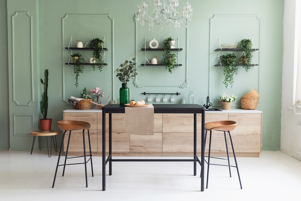 Eco Conscious Vegan Kitchen Design, Minimalist Kitchen in Green with breakfast table, chandelier and stools