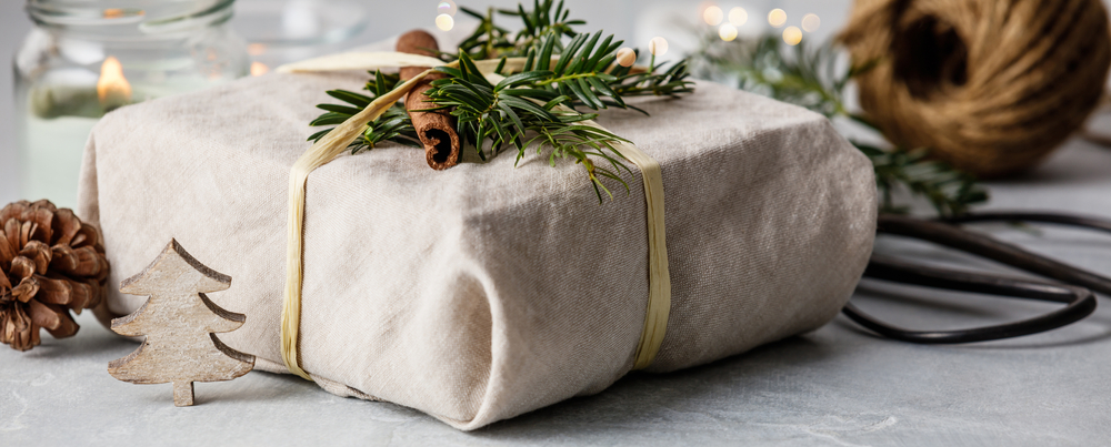 Sustainable holiday gift wrapping with cinammon, greenery and natural materials, view of gift wrapping materials and gift